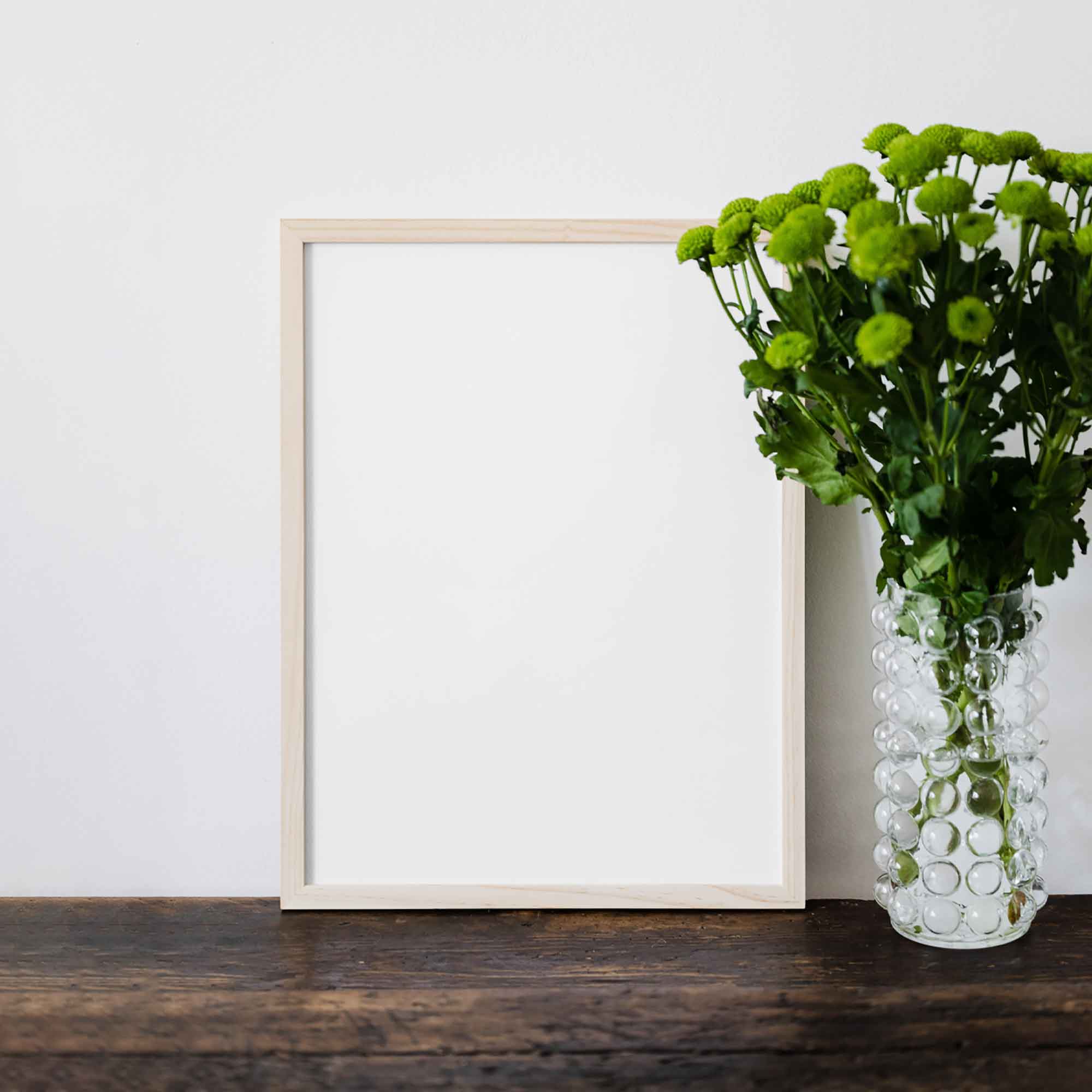 Free Poster Frame Against Wall Mockup