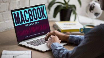 3/4 View Man Working on MacBook on Office Table Mockup