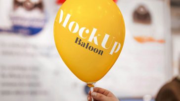 Free Hand Holding Balloon Mockup with Blurry Background