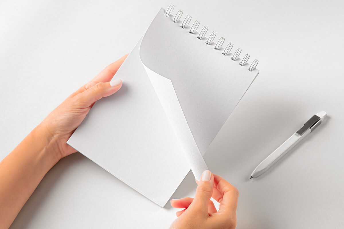 Free Hands Holding Spiral Notepad Mockup PSD