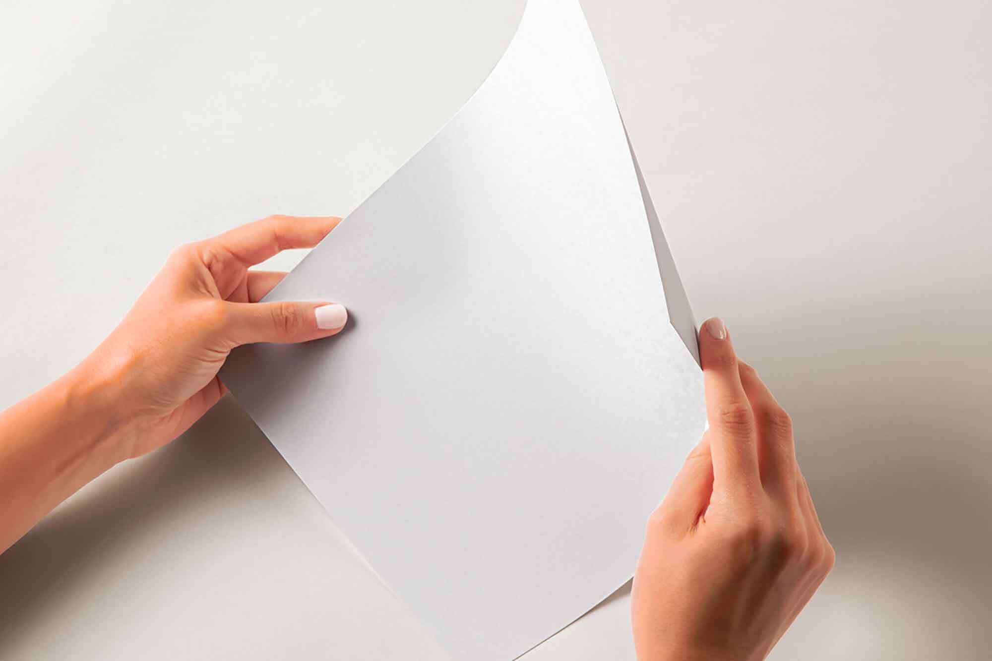 Free Hand Holding Glossy Paper Mockup PSD