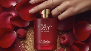 Luxury product photo of Calleby Endless Love Inspire perfume bottle surrounded by rose petals, gold glitter, and raspberries with a hand wearing gold rings.