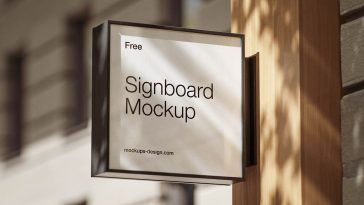 Square signboard mockup PSD mounted on modern storefront wall with realistic shadows